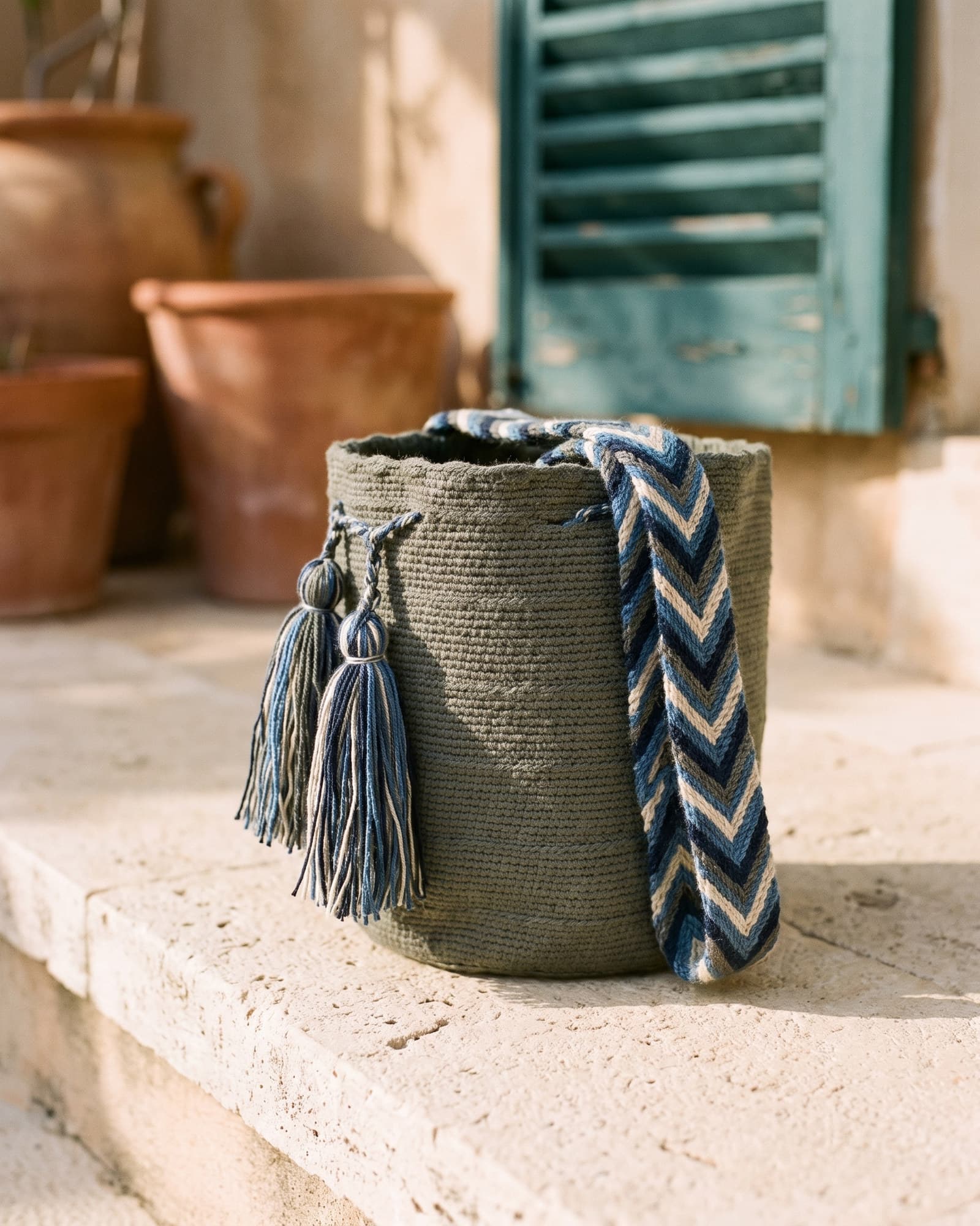 Handgewebte einfarbige Wayuu-Mochila in Olivgrau auf warmem Leinen