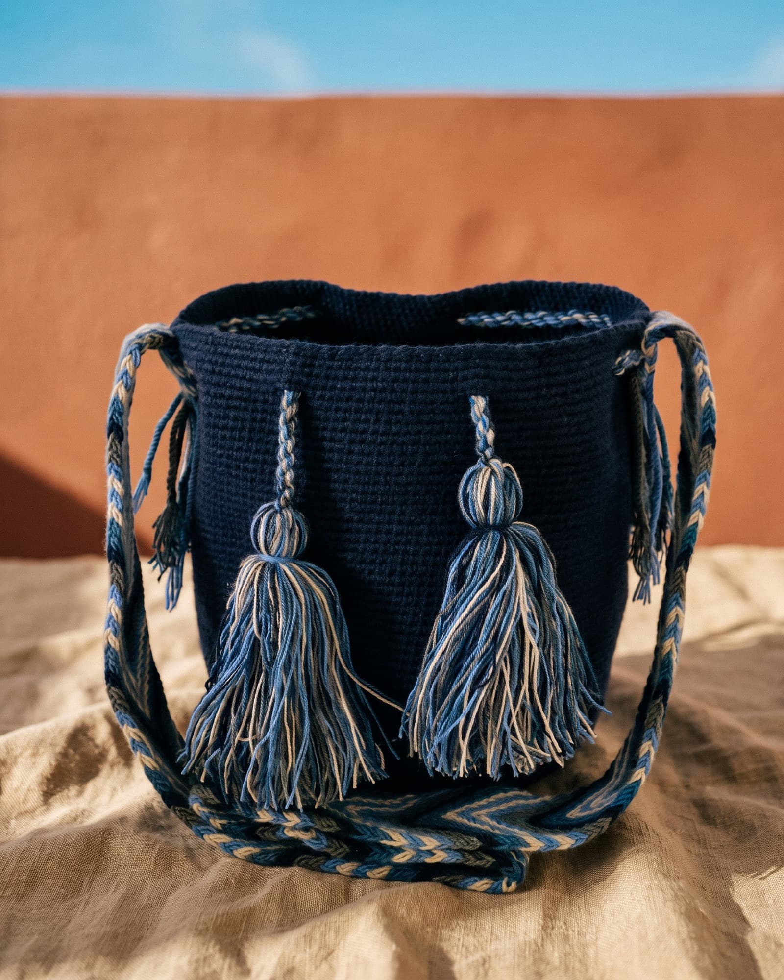 Handgewebte einfarbige Wayuu-Mochila in Marineblau auf warmem Leinen