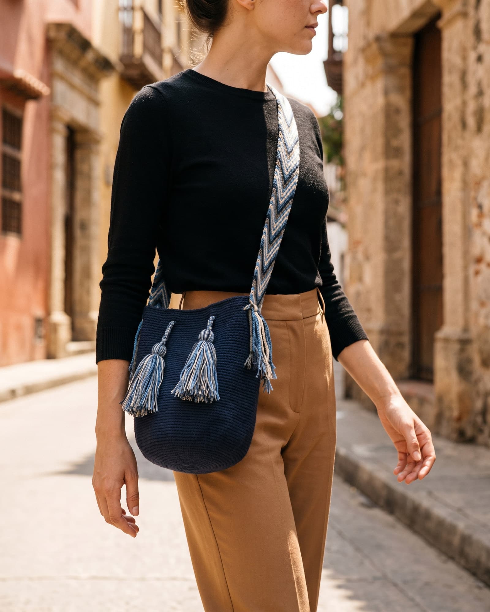 Die marineblaue Mochila getragen — crossbody in einer sonnigen Altstadtgasse